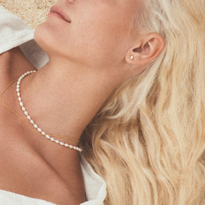 model wearing C.W. James pebble earrings, Astrid and Bianca necklaces